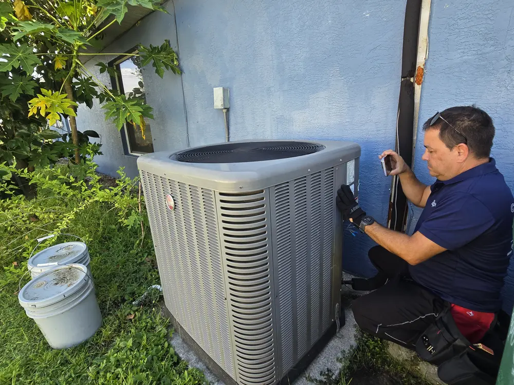 Coral Coast inspector examining an AC condenser unit