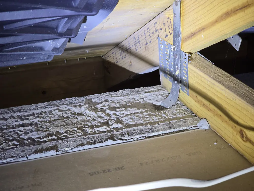 Hurricane strap connecting roof truss to wall framing, documented during a wind mitigation inspection